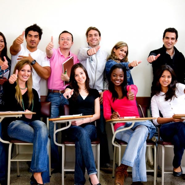 friends or university students smiling in a classroom